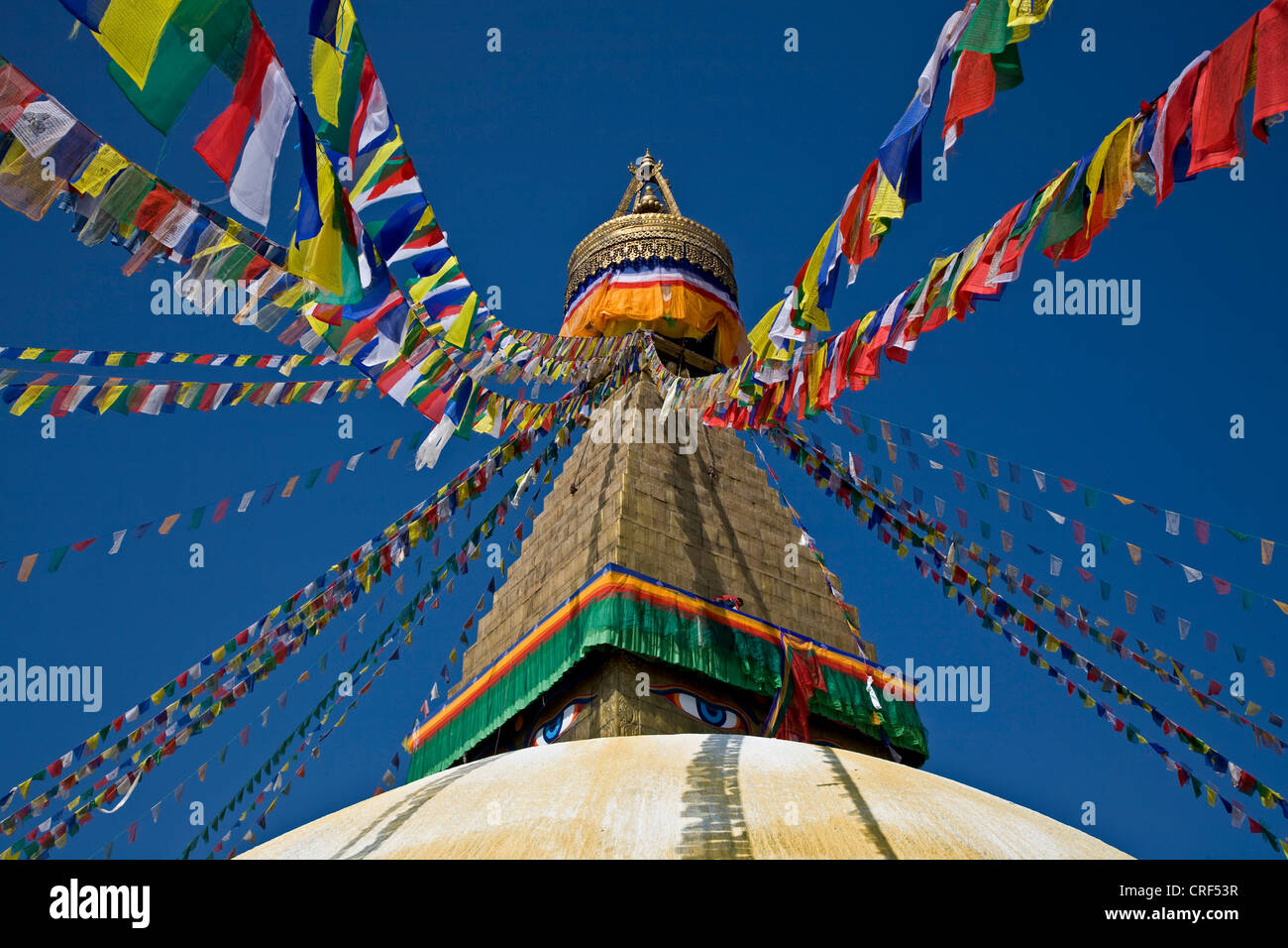 TIBETAN BUDDHIST PRAYER FLAGS fly from the top of BODHANATH STUPA, Nepal, Kathmandu Stock Photo