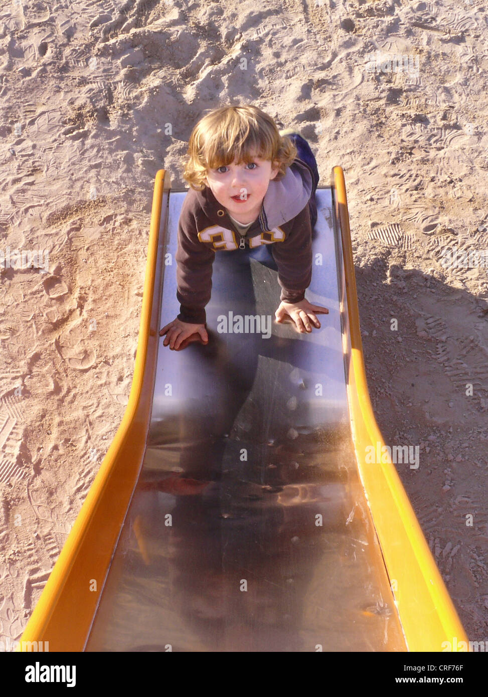 little boy climbing a slice on a playground Stock Photo