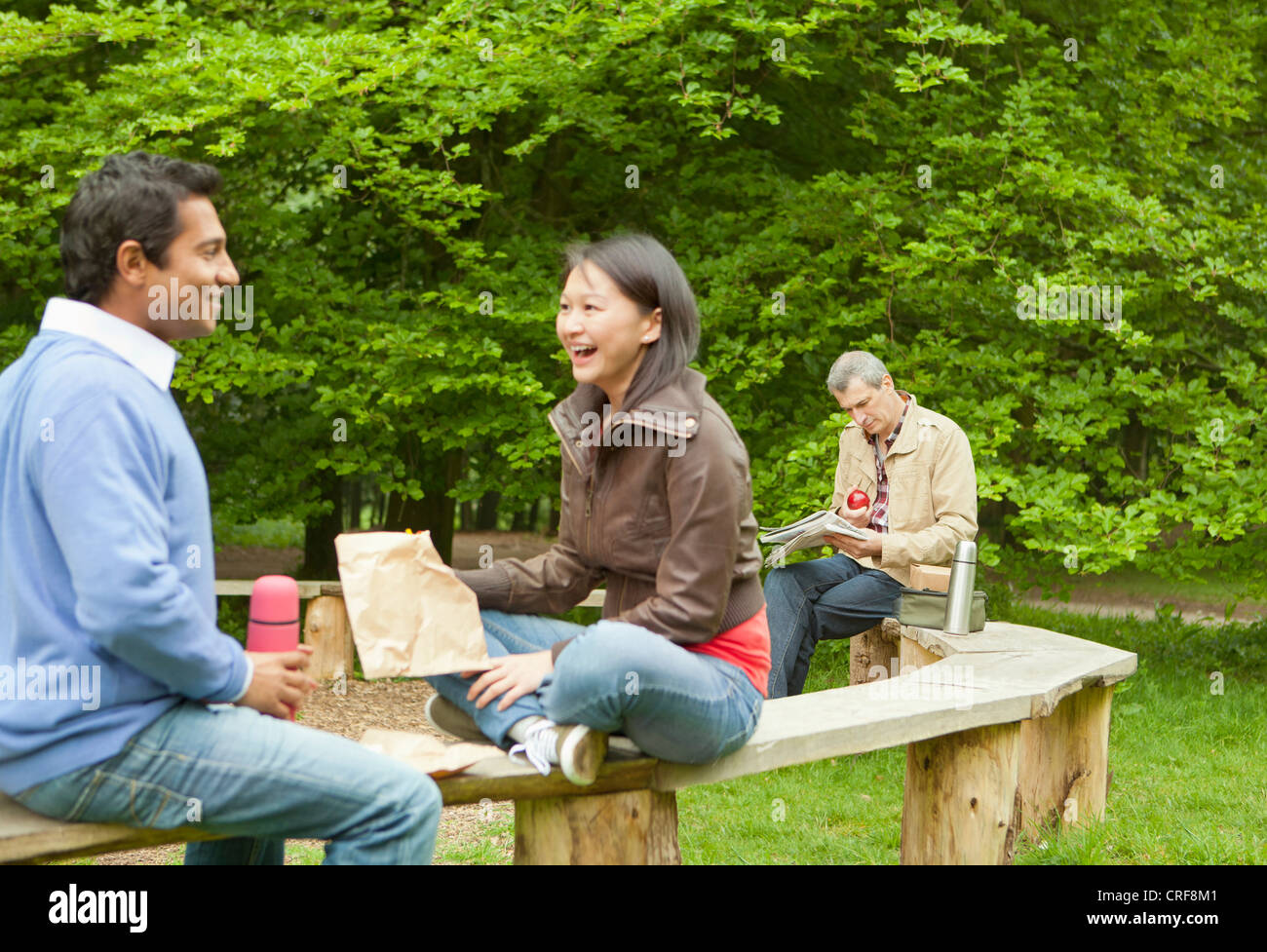 Couple talking on wooden bench in park Stock Photo