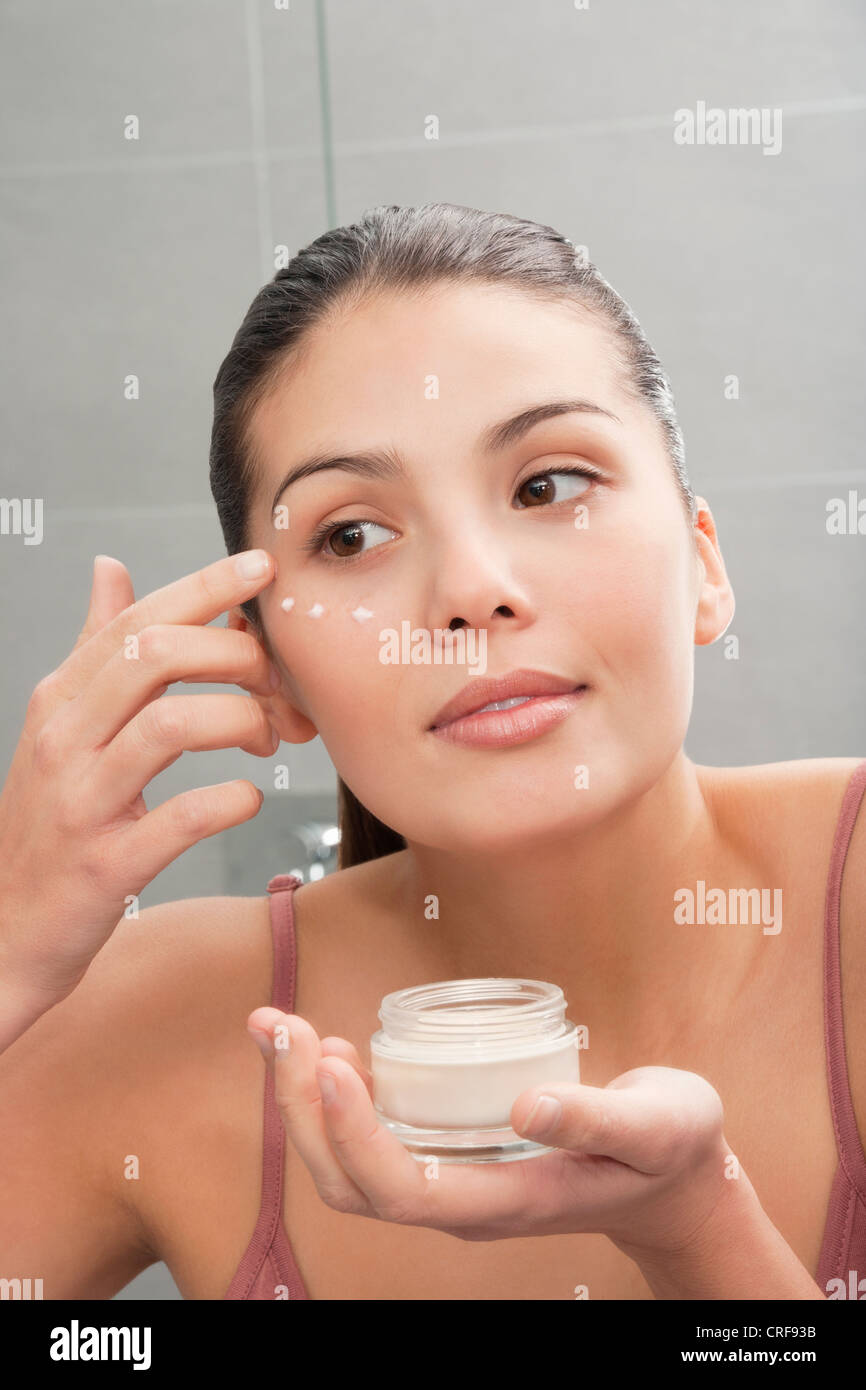 Woman applying moisturizer to face Stock Photo Alamy