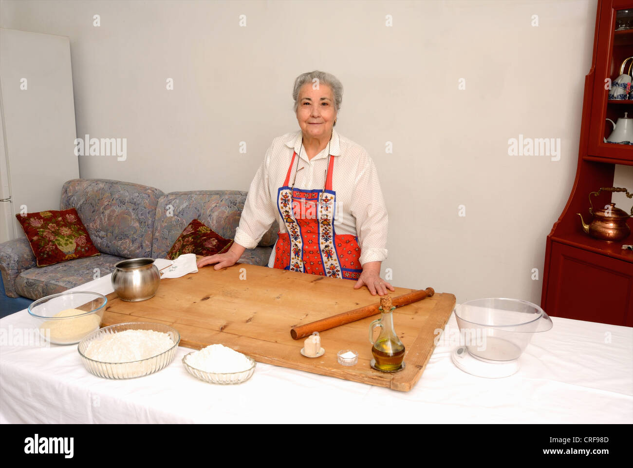 Older woman baking in living room Stock Photo