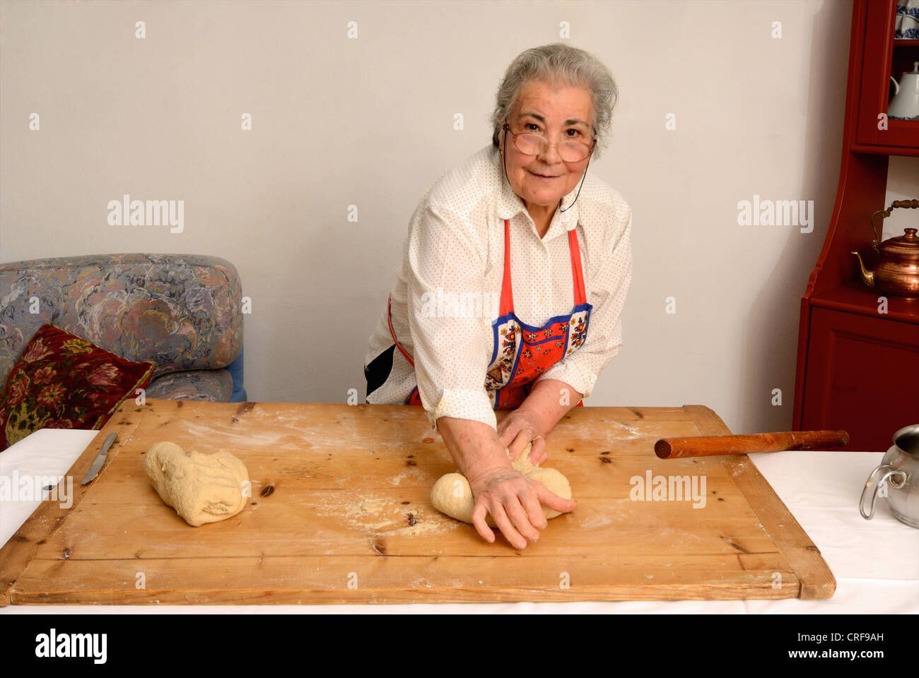 Older woman kneading dough on board Stock Photo