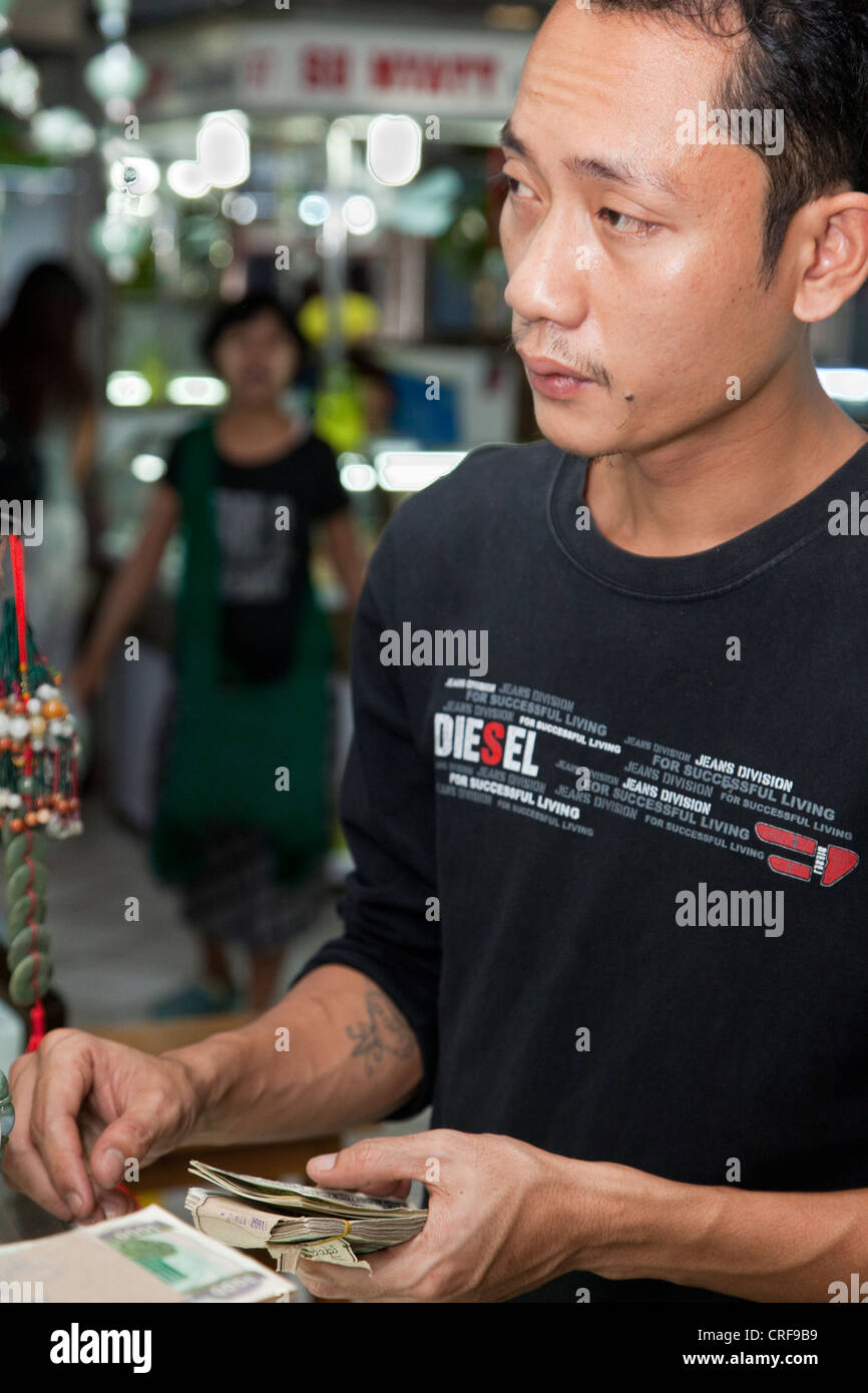 Myanmar, Burma, Yangon. A Moneychanger Changing Burmese Kyat for U.S