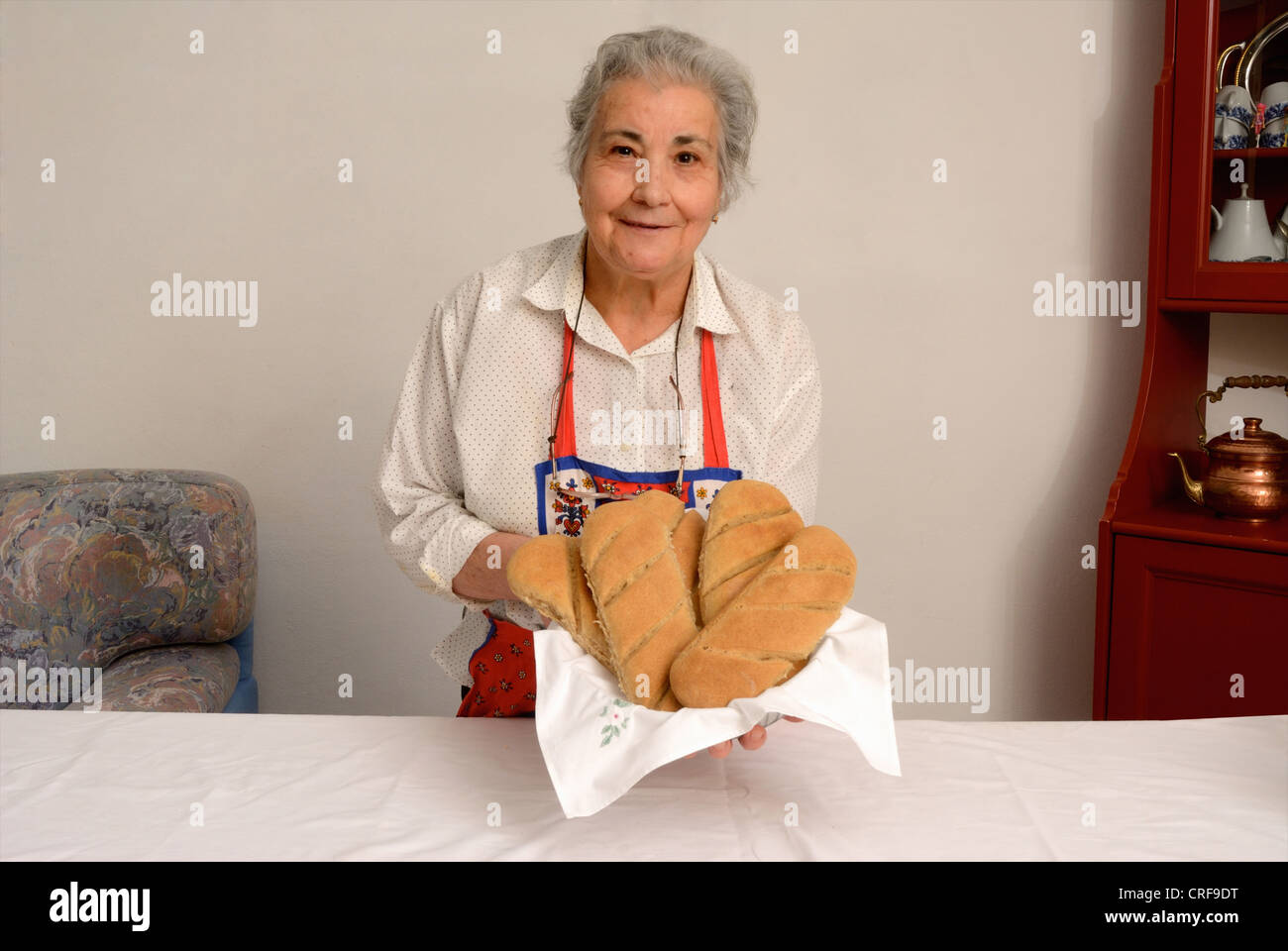 Older woman making bread in living room Stock Photo