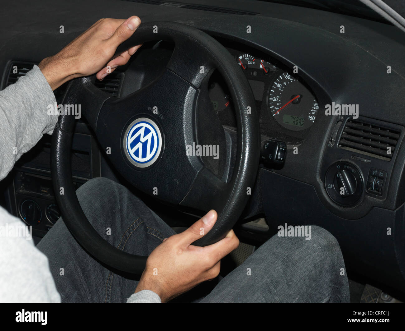 Afro-Caribbean Man's Hands Turning Car Steering Wheel Stock Photo