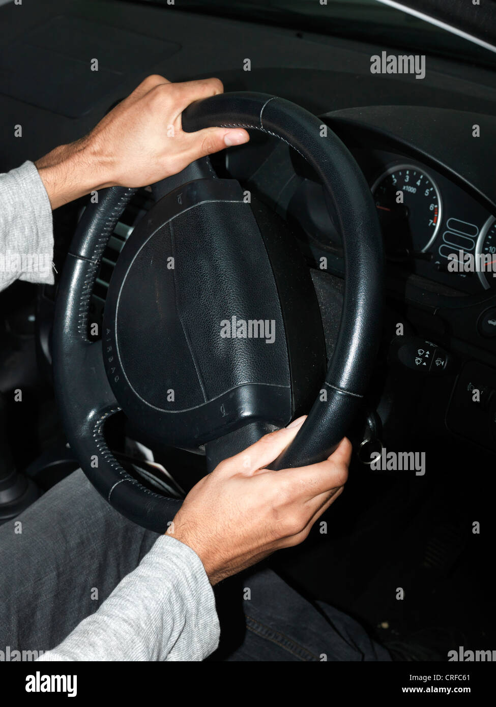 Afro-Caribbean Man's Hands Turning Car Steering Wheel Stock Photo