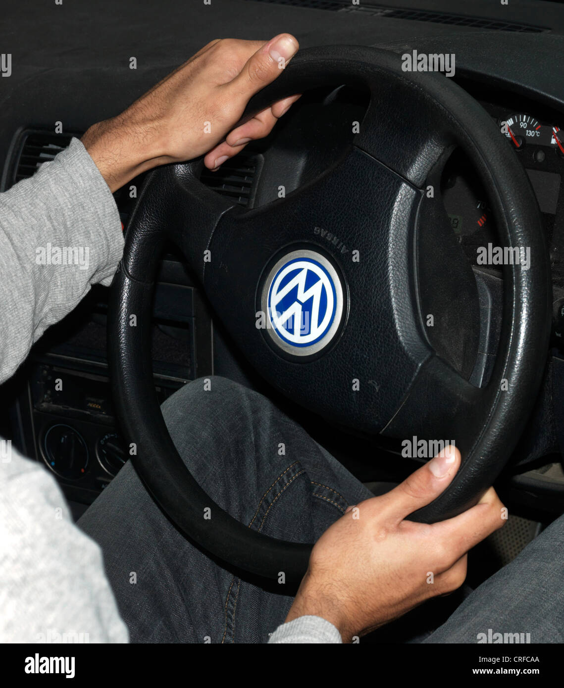 Afro-Caribbean Man's Hands Turning Car Steering Wheel Stock Photo