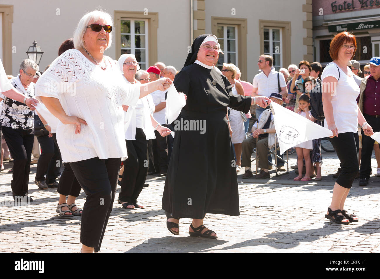 Nun dancing among other dancers in the streets of Echternach. Stock Photo