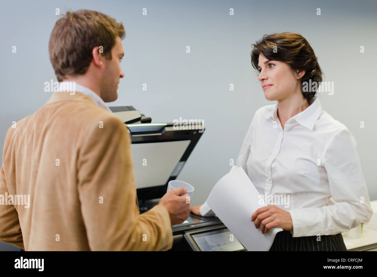 Business people talking at copier Stock Photo