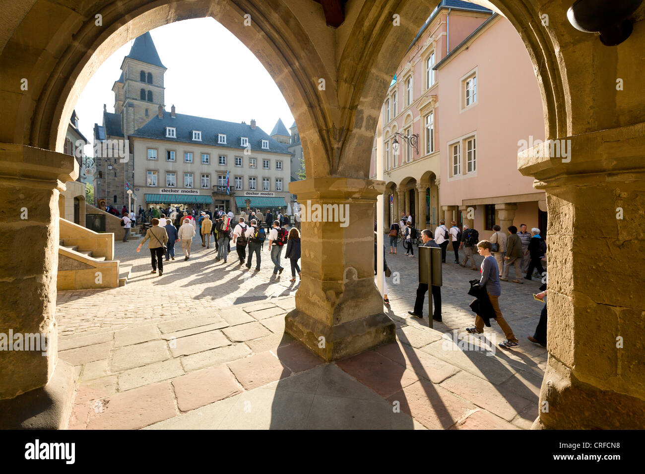 View on marquet square through the arcades of the medieval townhall Denzelt, dancers on the road for thejumping procession. Stock Photo