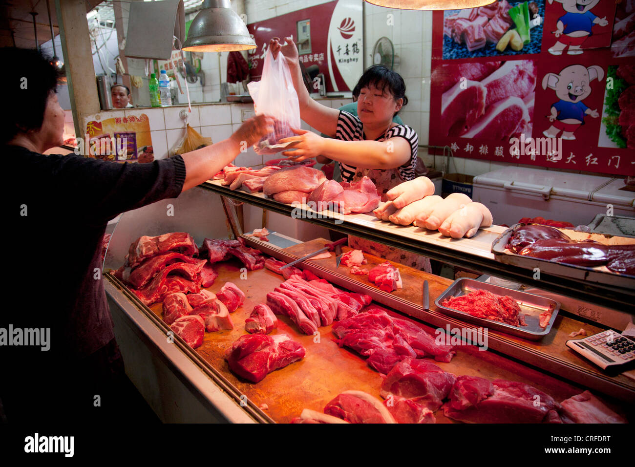 Sellers on stalls at in indoor wet market in an old Chinese style area of Fuchengmen, in the Xicheng district of Beijing, China. Stock Photo