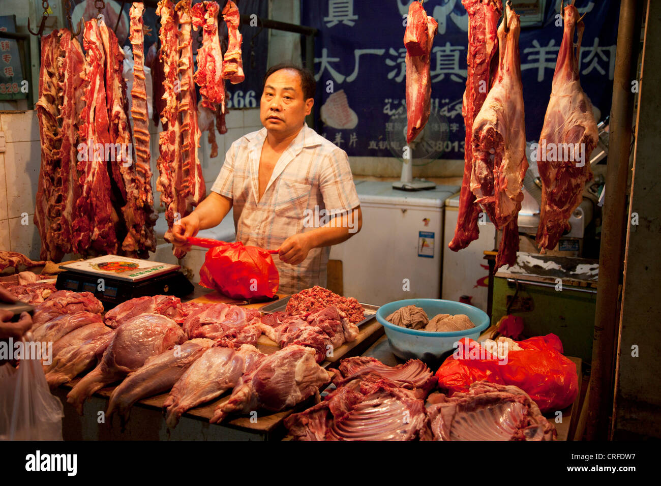 Sellers on stalls at in indoor wet market in an old Chinese style area of Fuchengmen, in the Xicheng district of Beijing, China. Stock Photo