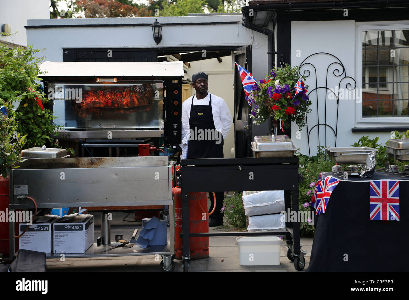 Chef With Pig On Spit At Street Party For The The Queen's Diamond Jubilee Surrey England Stock Photo