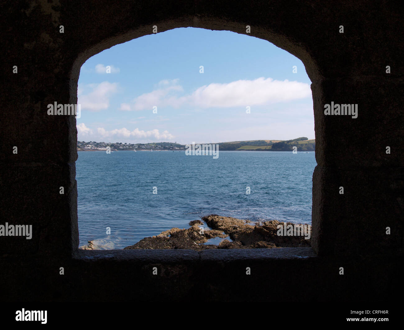 View of Fal Estuary through one of the gun ports of the blockhouse known as Little Dennis, Pendennis Point, Falmouth, Cornwall Stock Photo