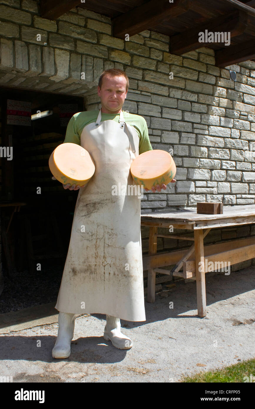 traditional cheese produktion: proud man with ready cheese wheels, Switzerland, Valais, Taeschalp, Zermatt Stock Photo
