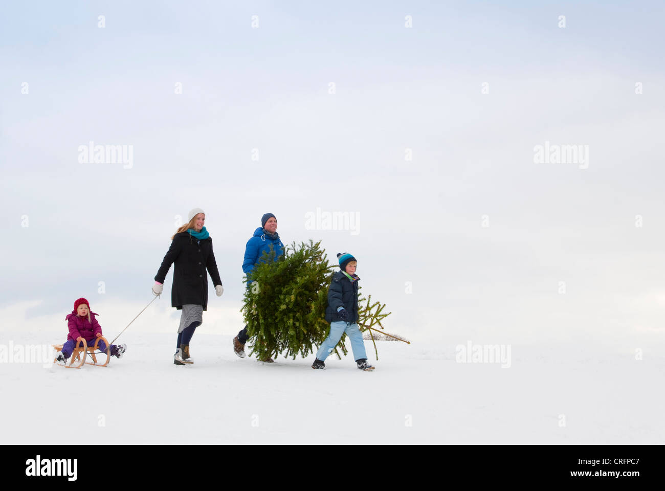 Family walking together in snow Stock Photo - Alamy