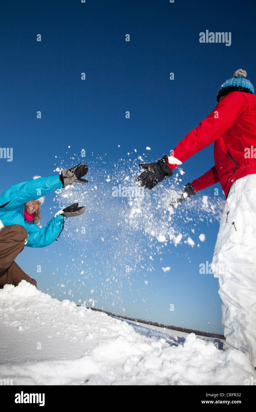Couple playing with snow in field Stock Photo - Alamy