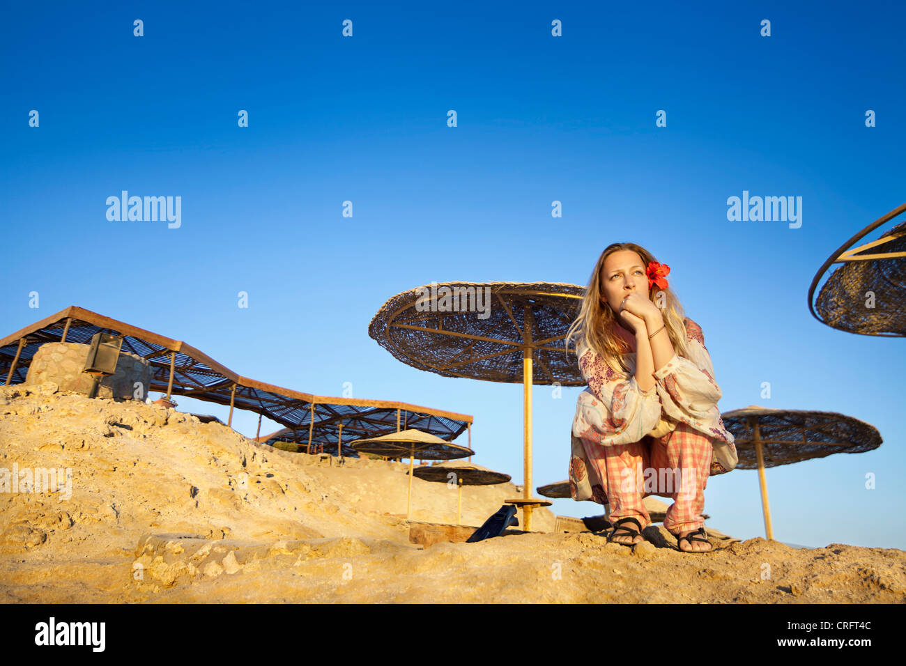 Woman sitting on beach cliffs Stock Photo - Alamy