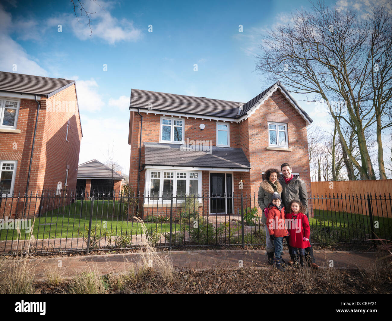 Family smiling outside house Stock Photo - Alamy