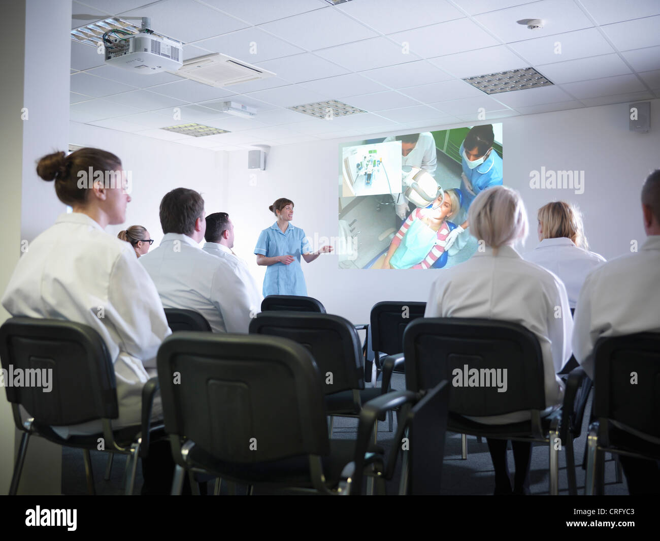 Dentist teaching students in class Stock Photo