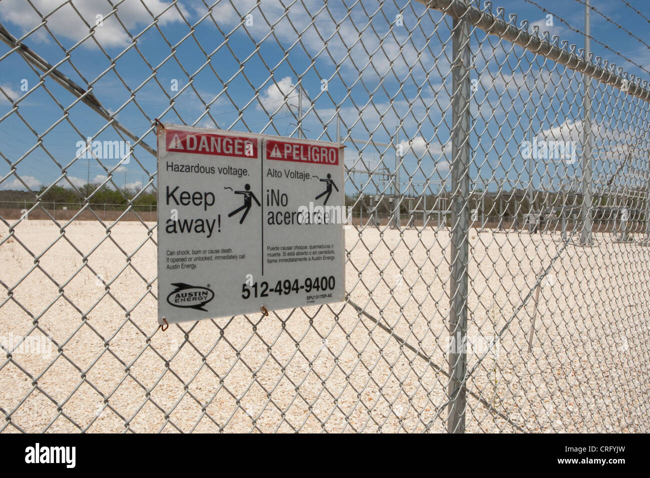 Keep away danger sign on chain link fence at solar power farm in Texas