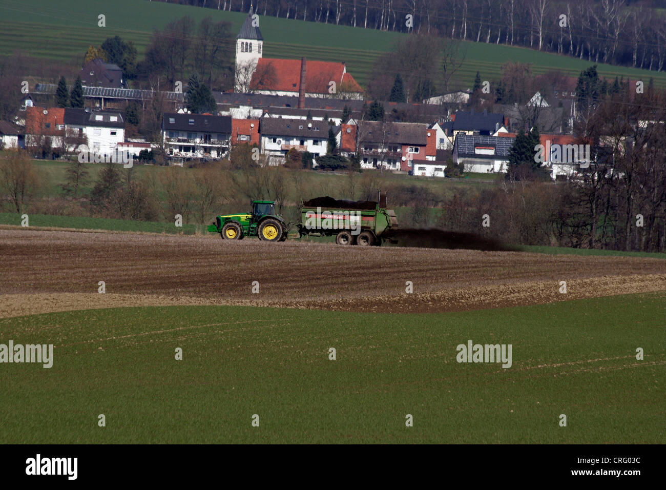 tractor with manure spreader manuring, Germany, North Rhine-Westphalia, Sauerland, Menden Stock Photo
