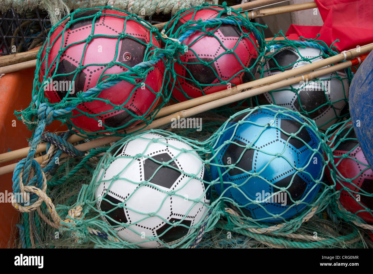 Coloured Footballs used as fishing floats. Fishing net Stock Photo