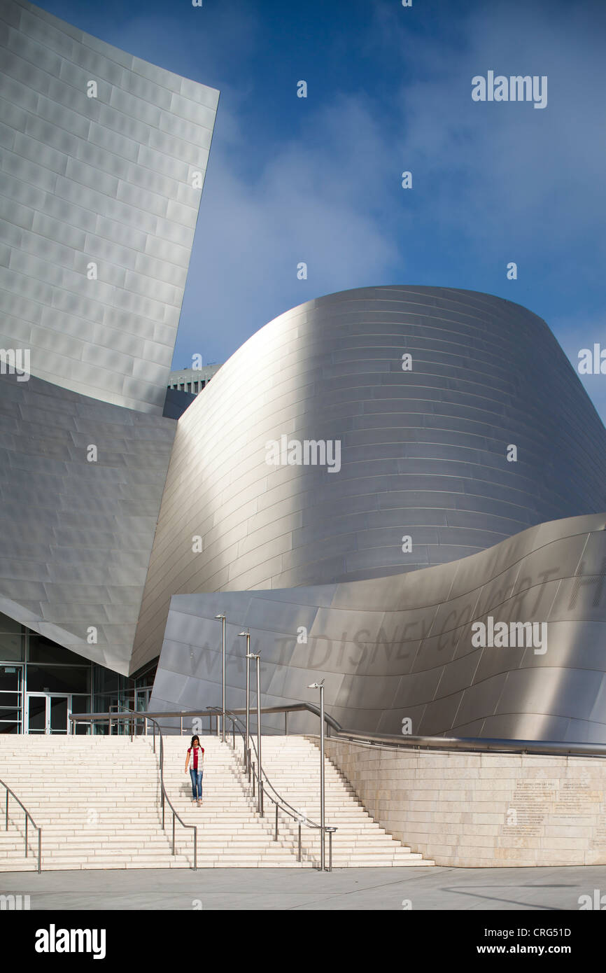 A female walks down some steps at the modern and striking architecture of the Los Angeles Philharmonic at Walt Disney Concert Ha Stock Photo