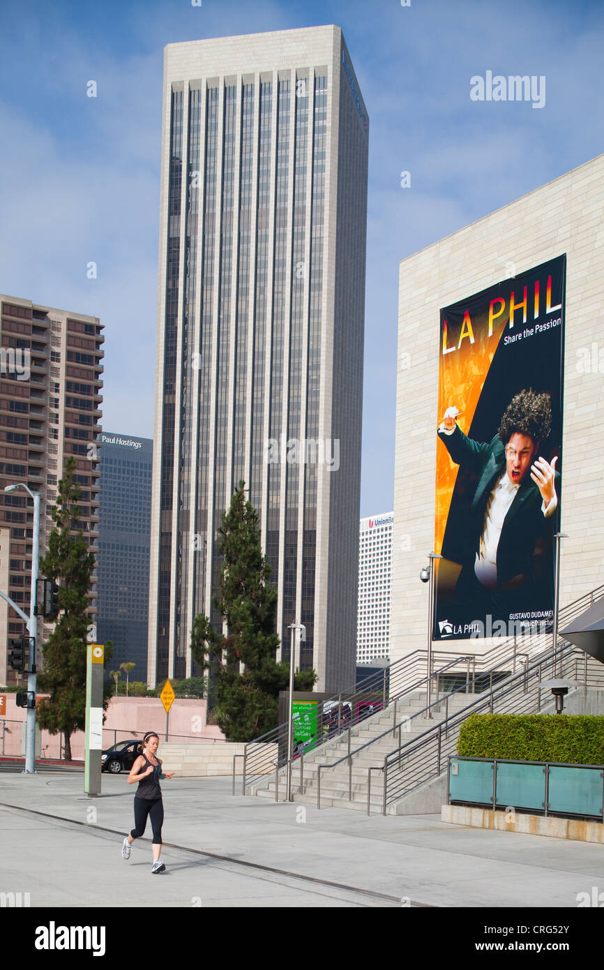 A female runs near the Los Angeles Philharmonic at Walt Disney Concert Hall on a sunny day in downtown LA. Stock Photo