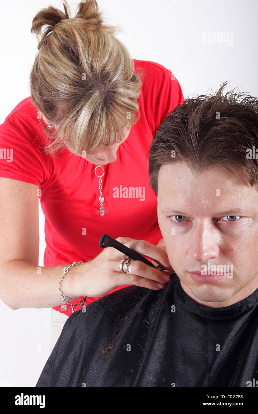 man at hairdresser. The female hairdresser uses a razor Stock Photo Alamy
