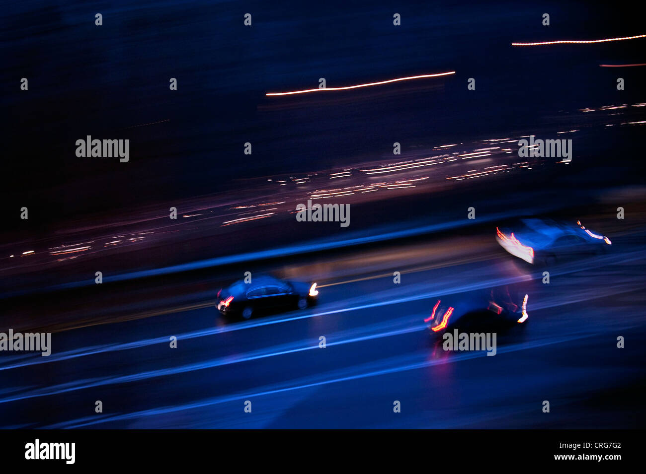 Cars speed down the parkway at night. Stock Photo