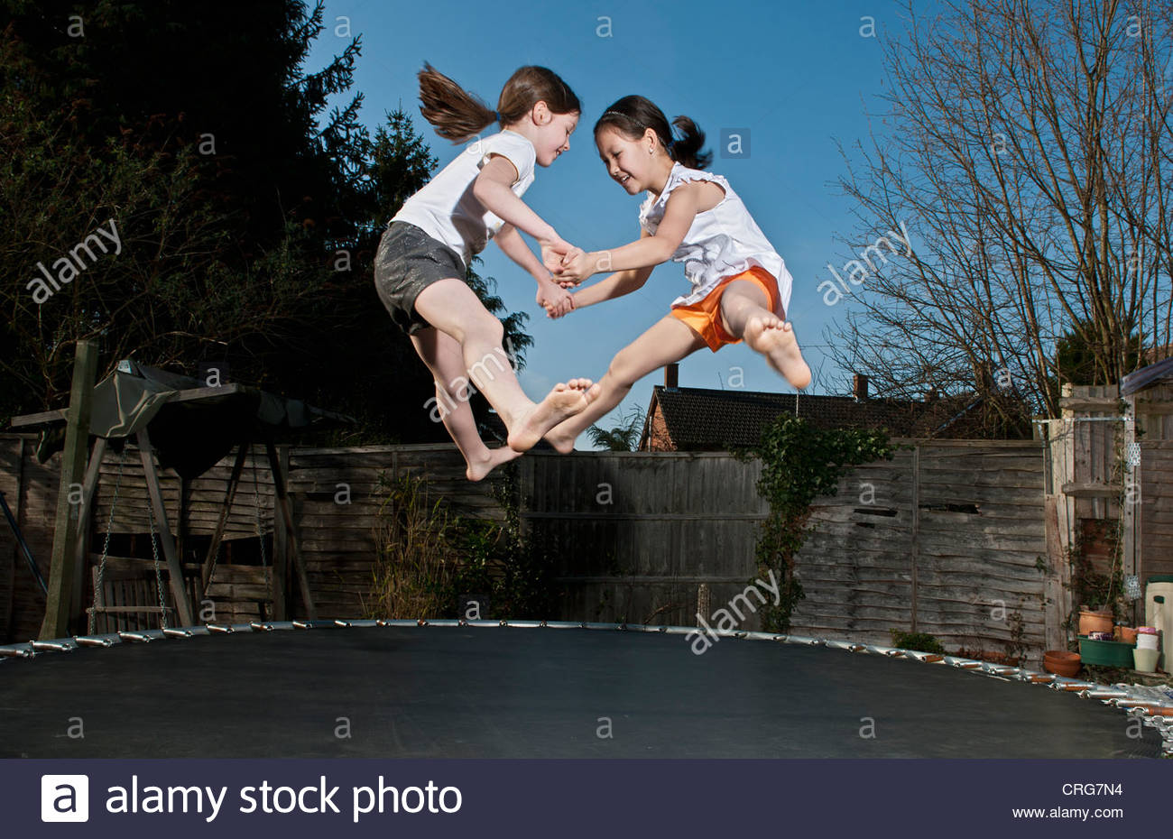 Girls jumping together on trampoline Stock Photo 48915136 Alamy