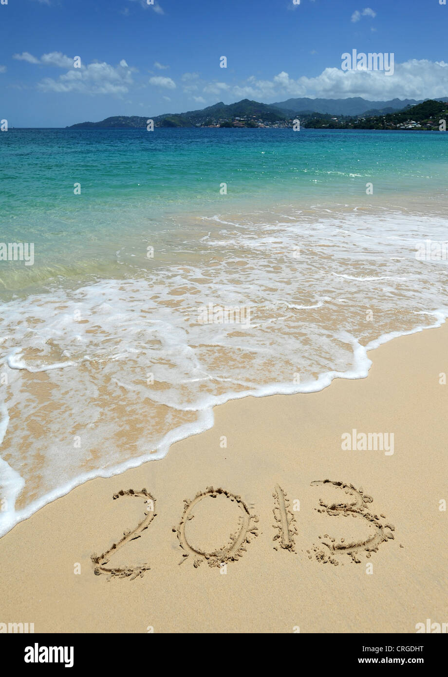 2013 written in the sand on Grand Anse Beach looking towards St George's, the capital of Grenada, West Indies. Stock Photo