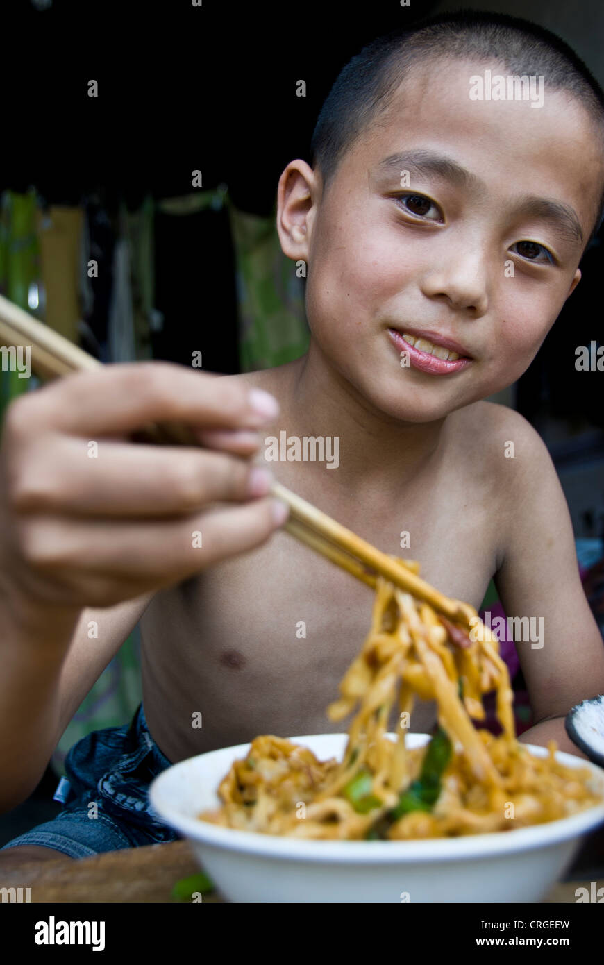 Chinese kid eating noodles. Pingyao, Shaanxi province. China Stock