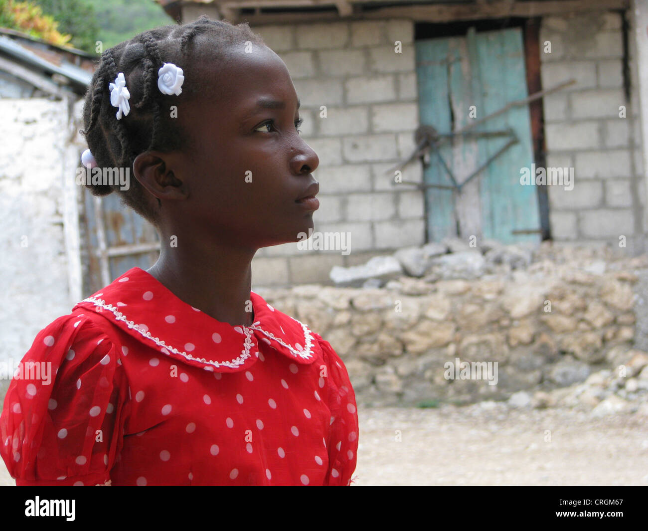 young black girl with braces and red dress standing in front of simple