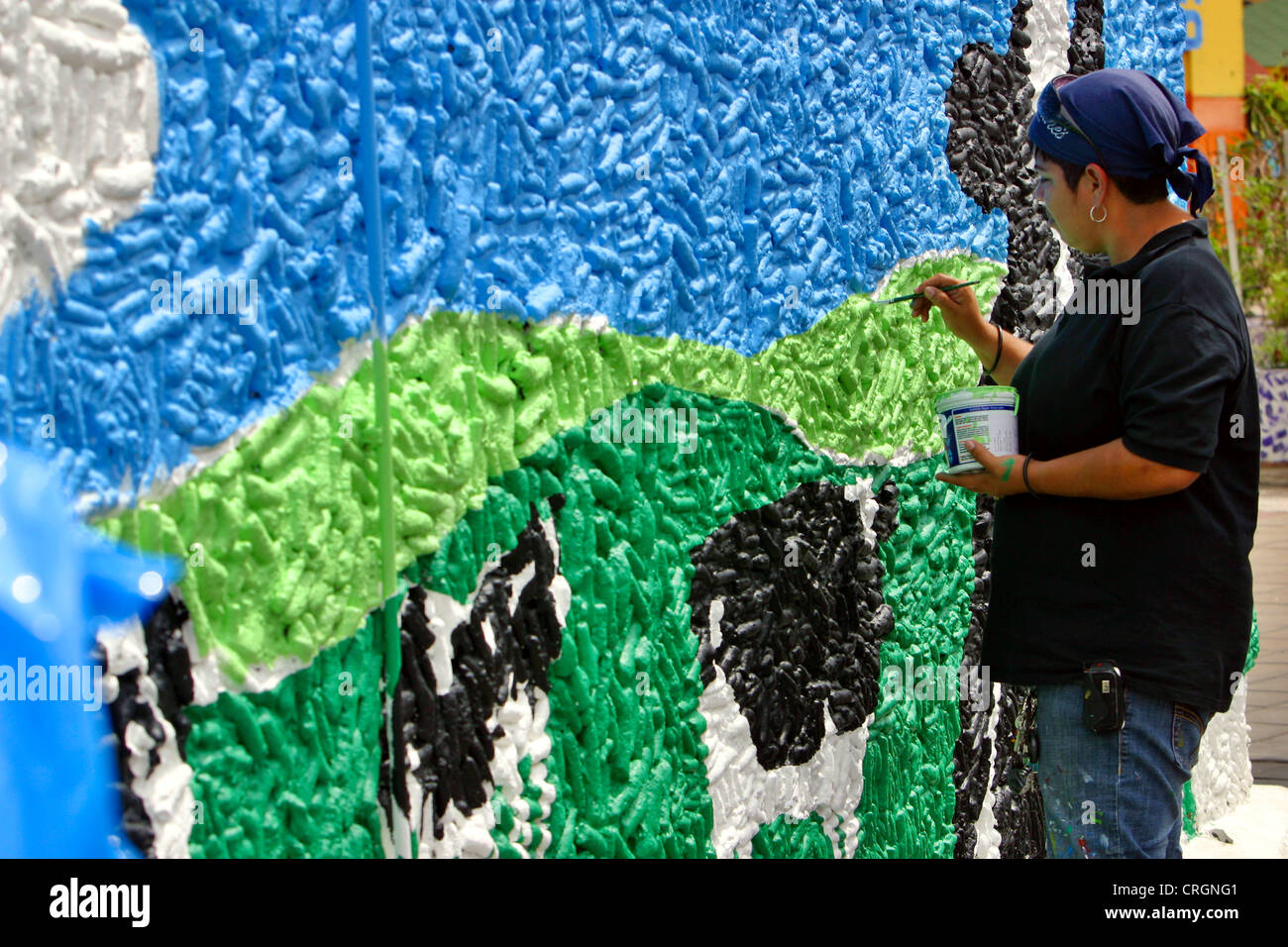 woman painting wall with landscape, Netherlands Antilles, Curacao, Punda, Willemstad Stock Photo