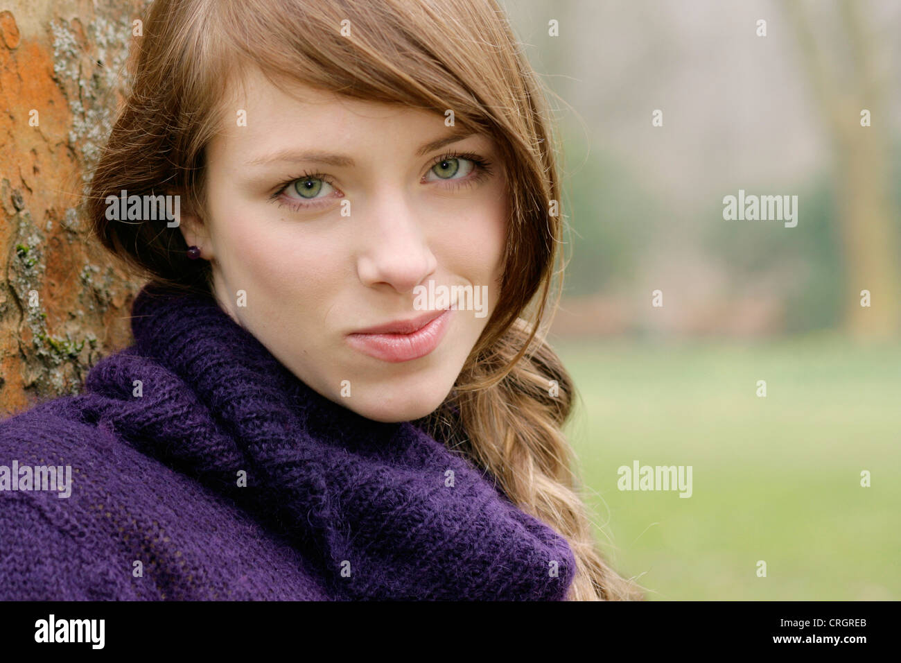 nice young woman leaning at a stem, Germany Stock Photo