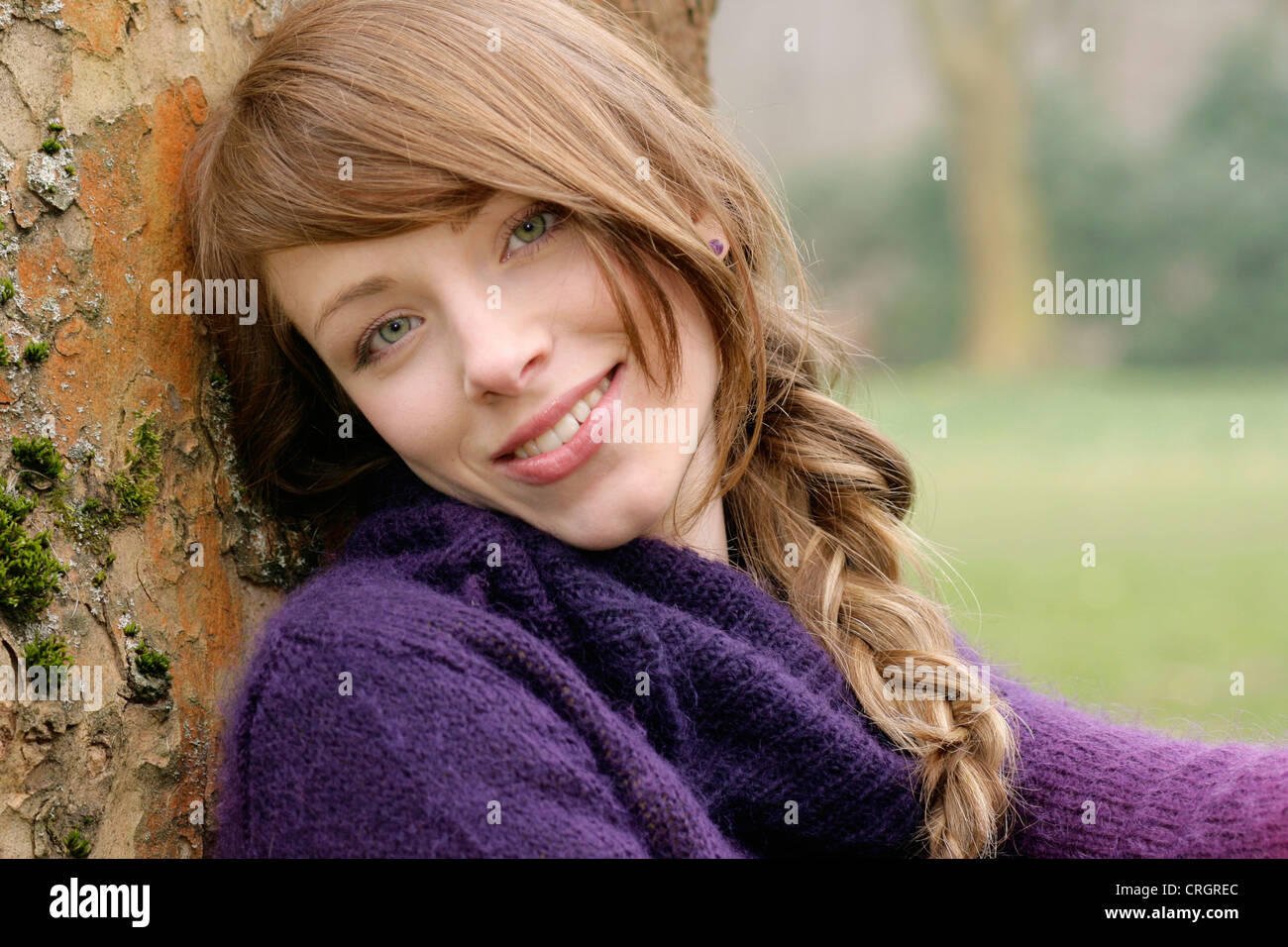 nice young woman leaning at a stem Stock Photo