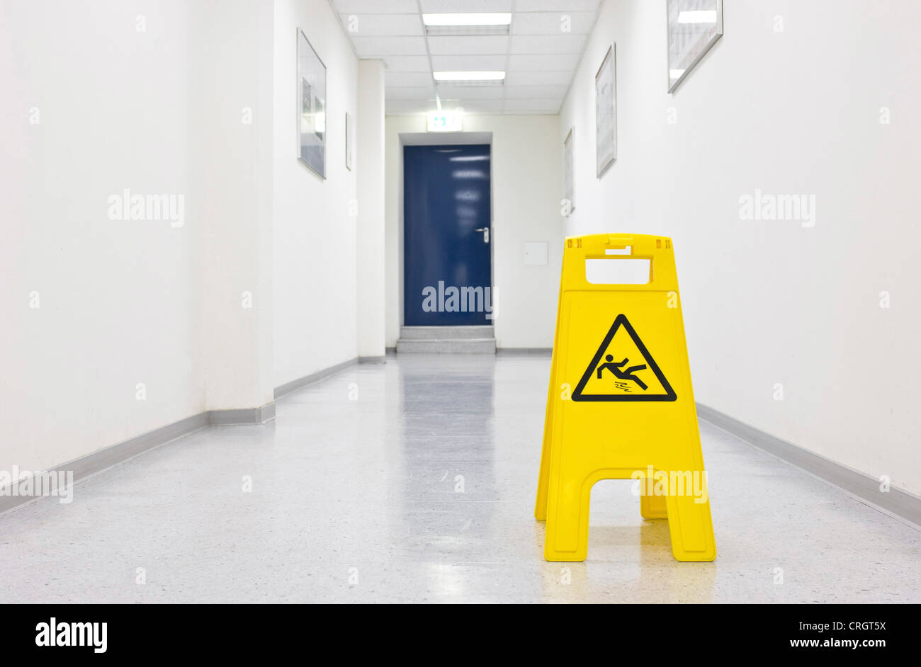 warning sign in a corridor saying 'attention - slip hazard' Stock Photo