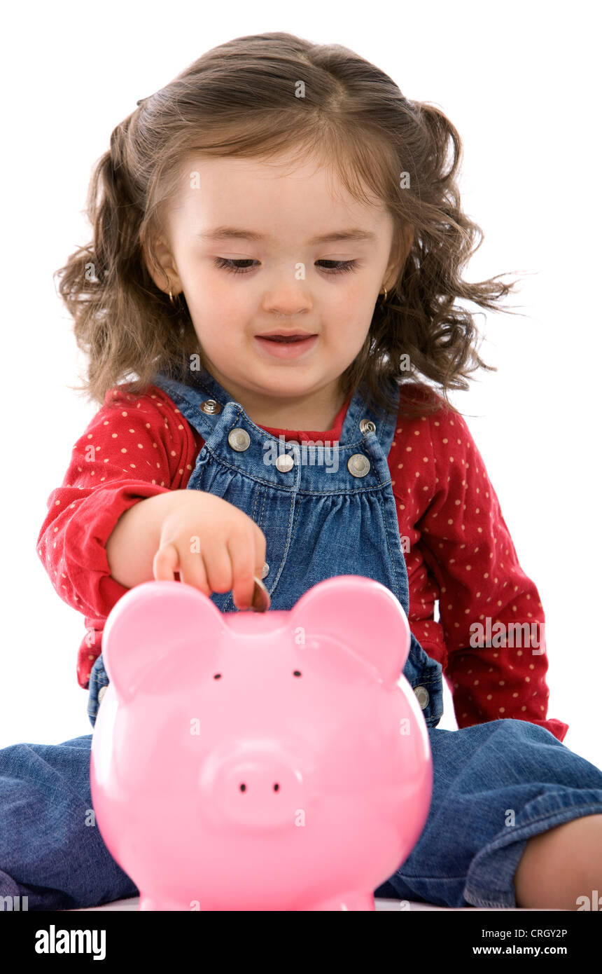 little girl putting a coin on her piggy bank Stock Photo - Alamy