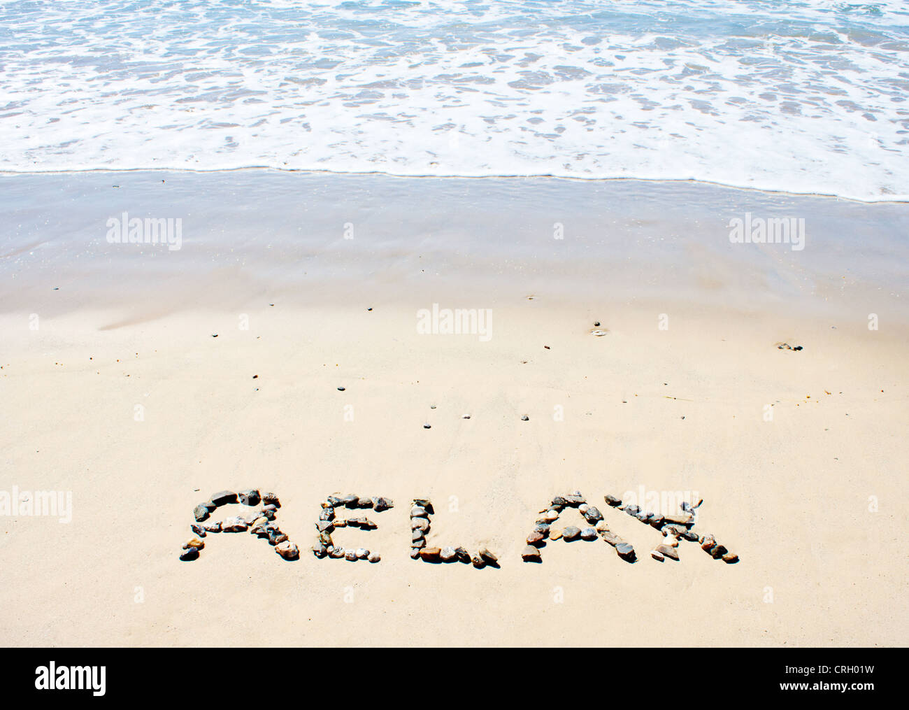Relax written in sand at beach Stock Photo