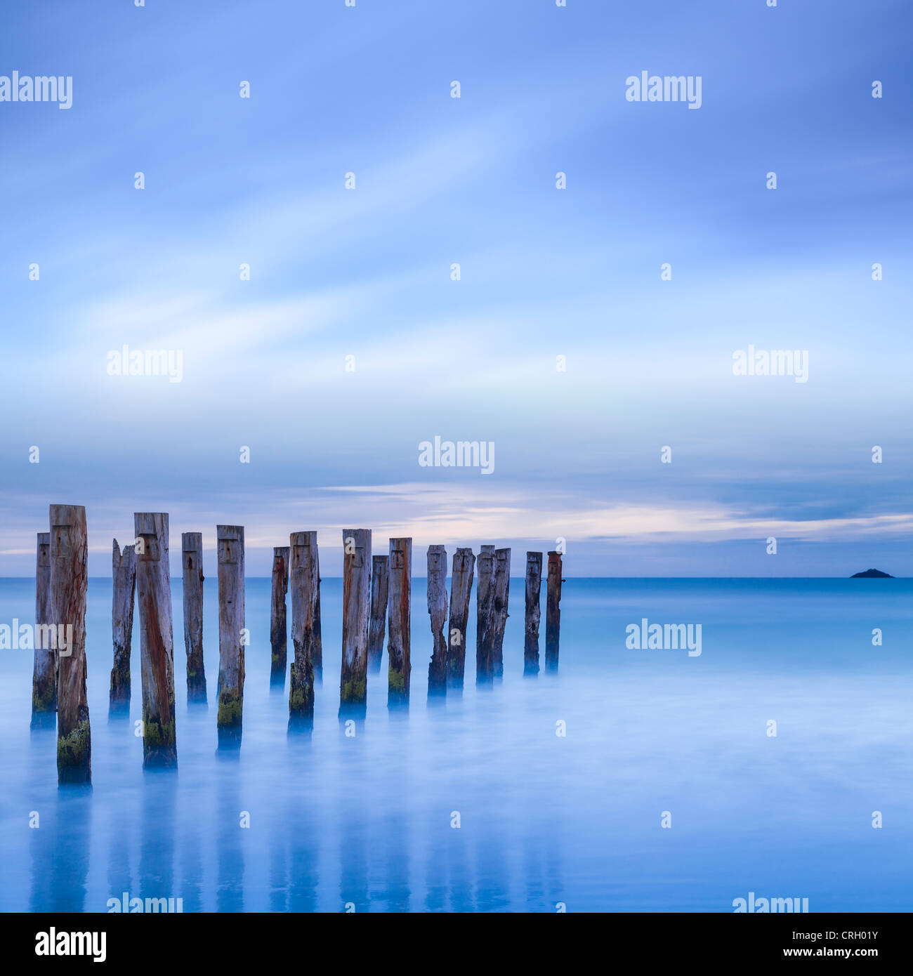 The remains of an old jetty on the beach near Dunedin, New Zealand, just before dawn, square. Stock Photo