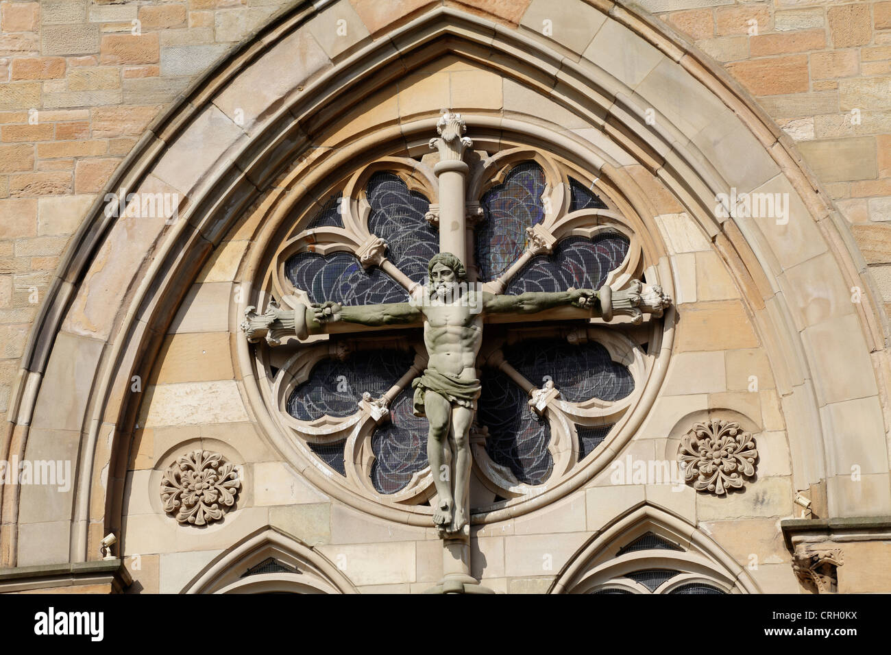 Stone carving of Jesus Christ on the cross on the façade of St Mungo's Roman Catholic church, Parson Street, Townhead, Glasgow, Scotland, UK Stock Photo