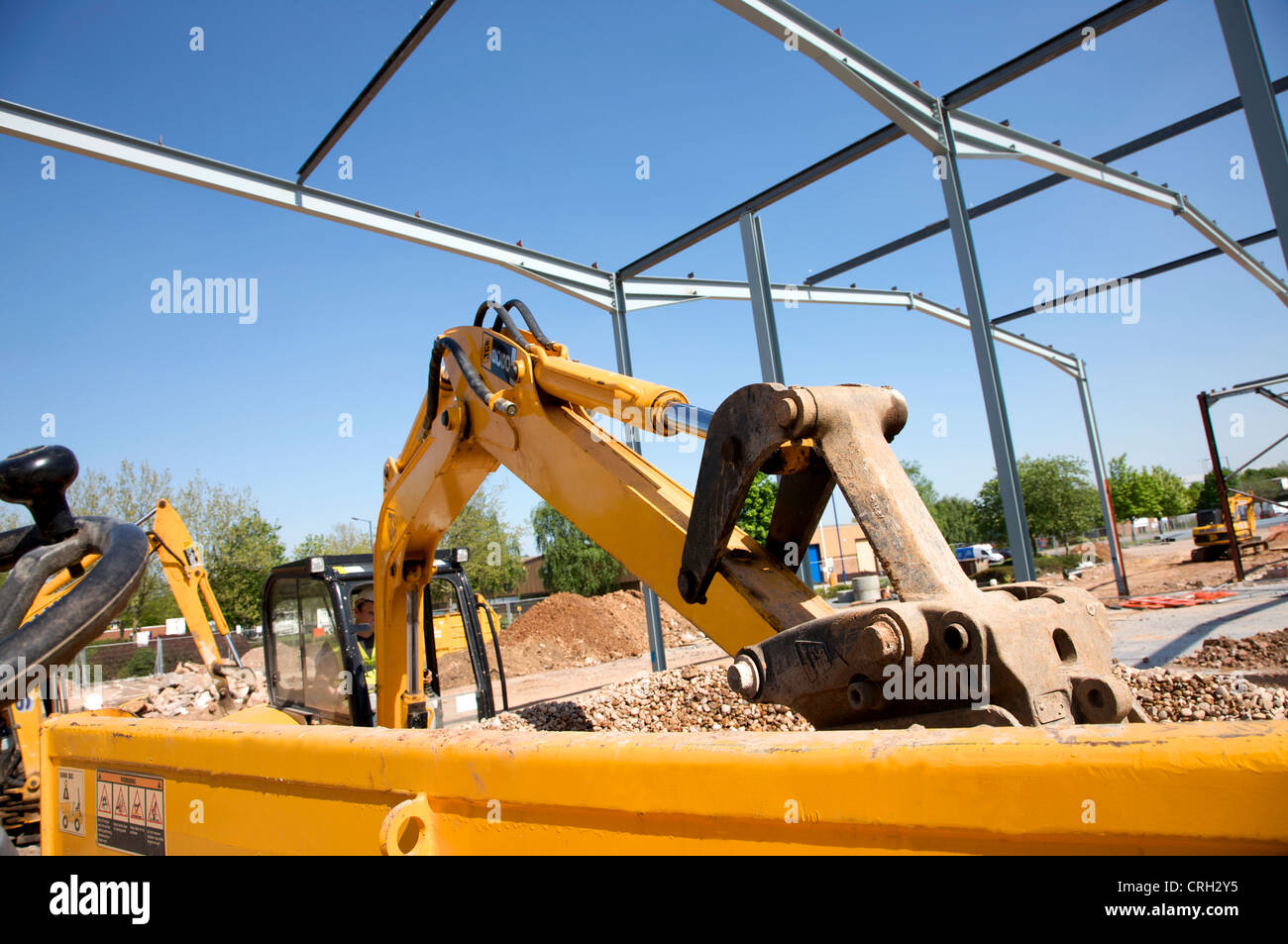 digger putting rubble into dumper truck at construction site near