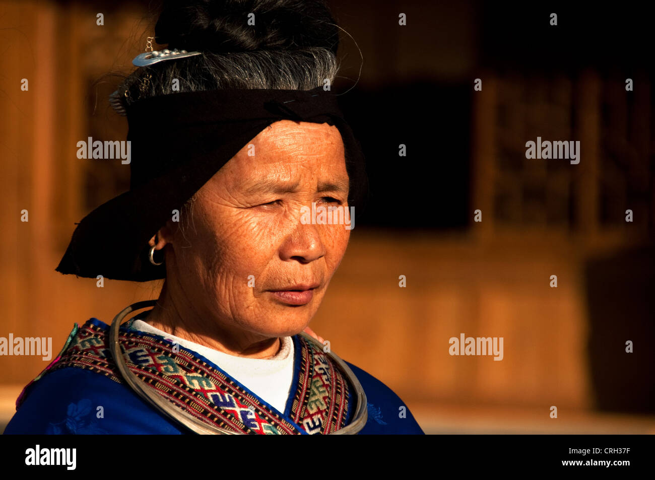 An elderly Miao woman with traditional clothes, hairstyle and silver ...