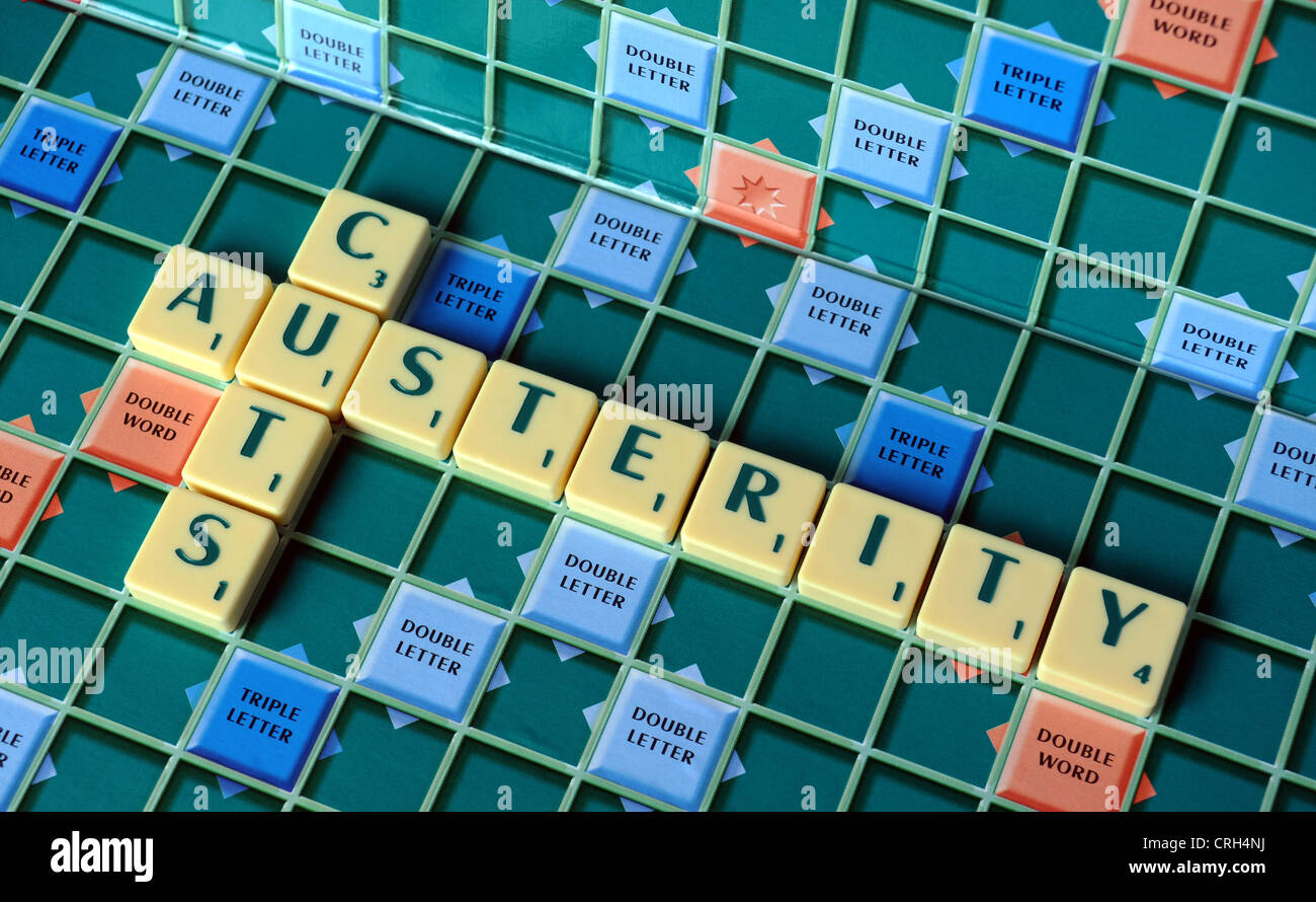 SCRABBLE GAME LETTERS ON BOARD SPELLING AUSTERITY CUTS RE THE ECONOMY CUTBACKS WAGES INCOMES SAVINGS HOUSEHOLD BUDGETS CREDIT UK Stock Photo