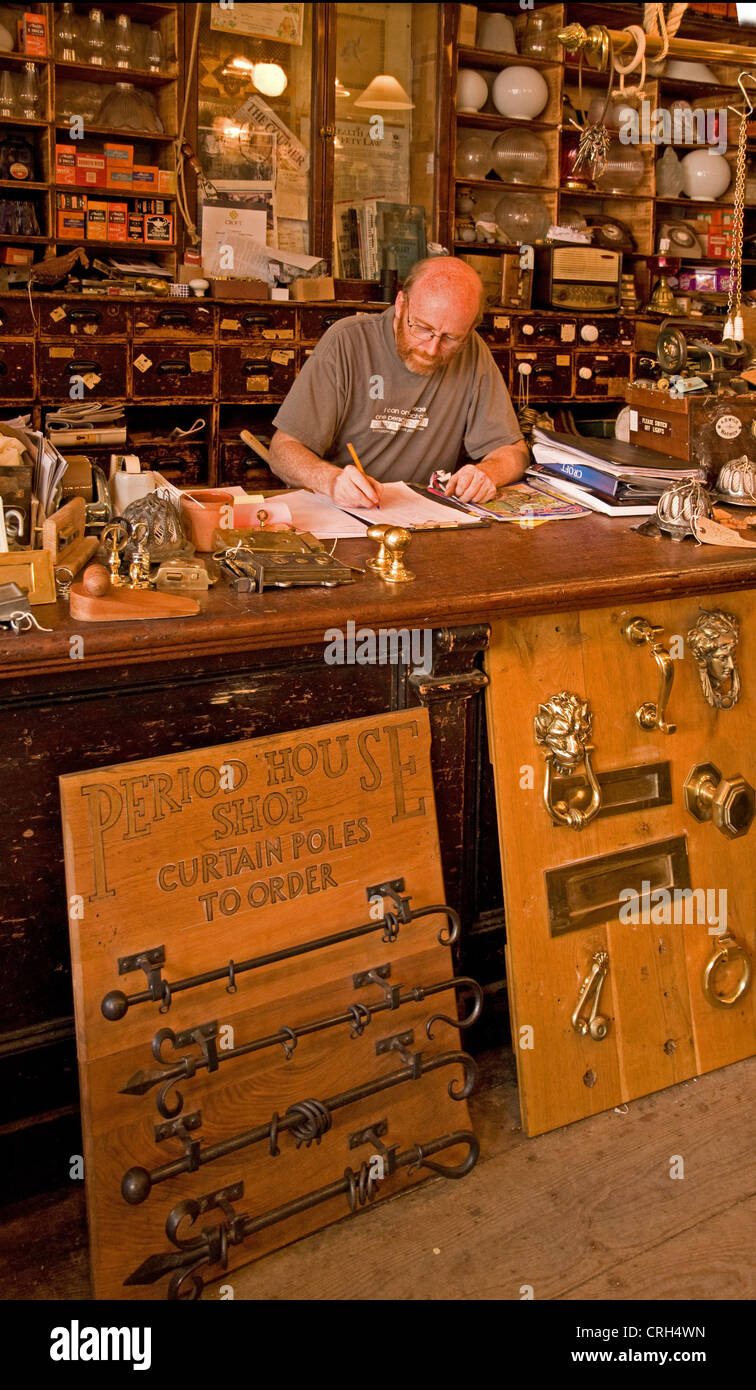 Man at counter of nostalgic interior of old fashioned ironmongers shop on Swan Street Warwick England Stock Photo