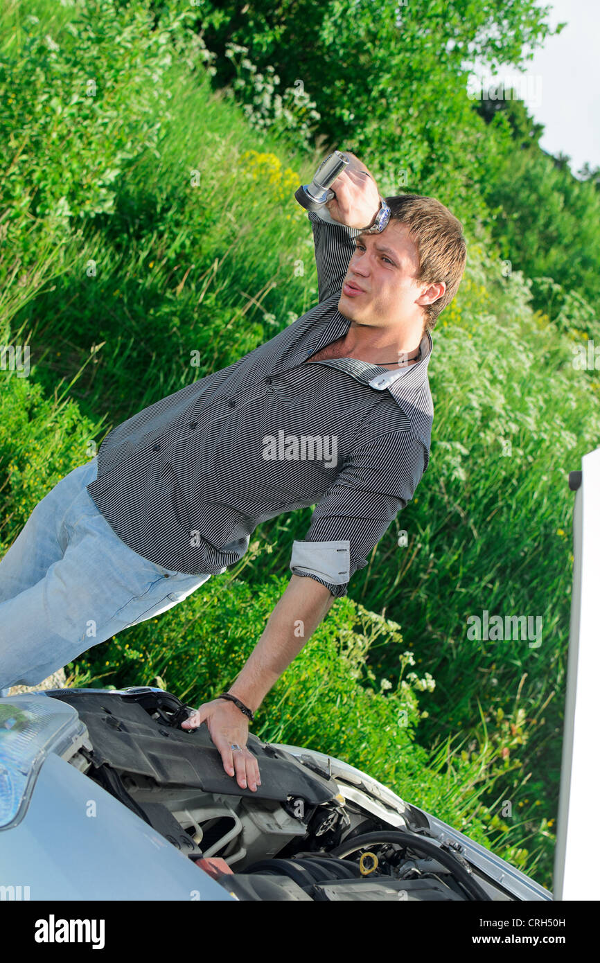 Young man repairing broken car with a socket spanner wrench Stock Photo