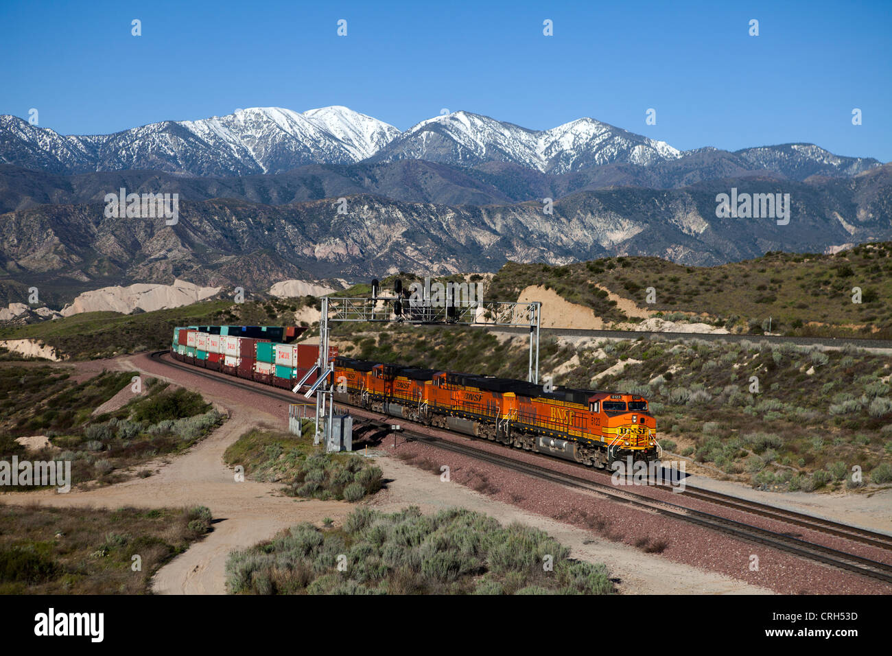Burlington Northern Santa Fe container train in Cajon Pass, CA, with the San Gabriel Mountains in the background. Stock Photo