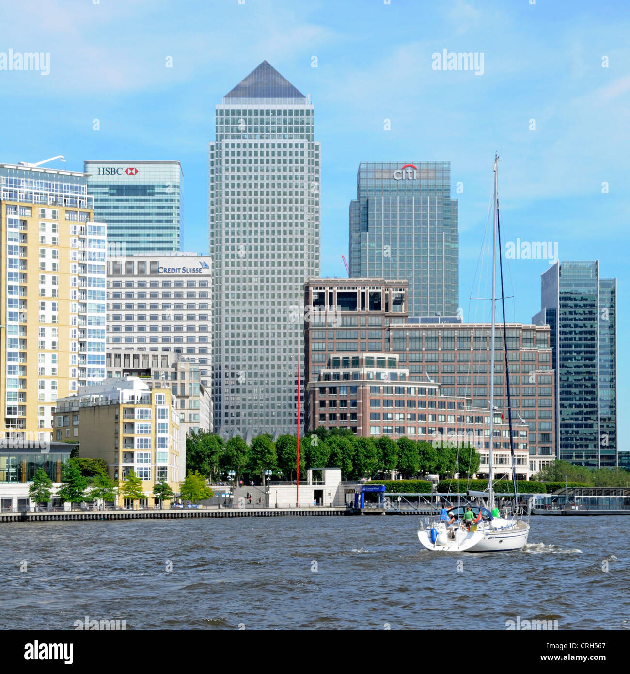 Yacht passing the Canary Wharf docklands complex on a high tide view ...